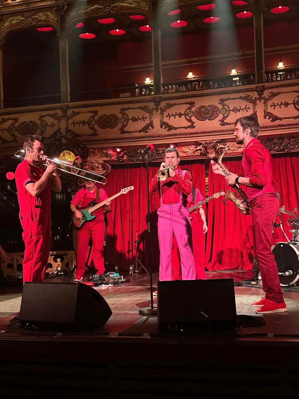 Músicos vestidos de rojo tocan en un teatro